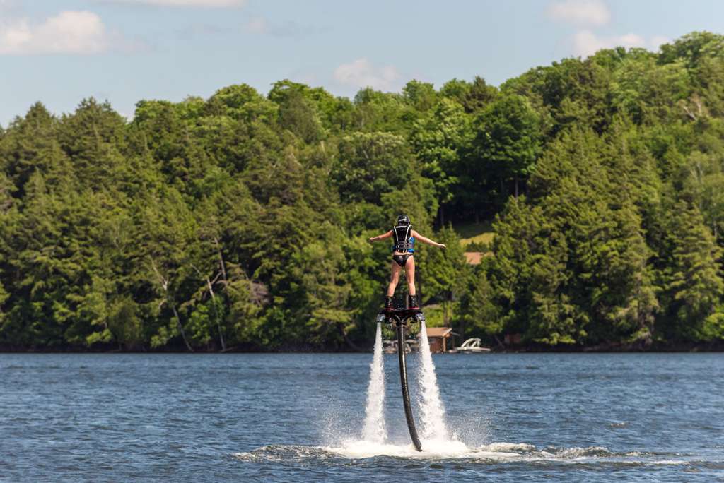 Young guest trying fly boarding on the lake