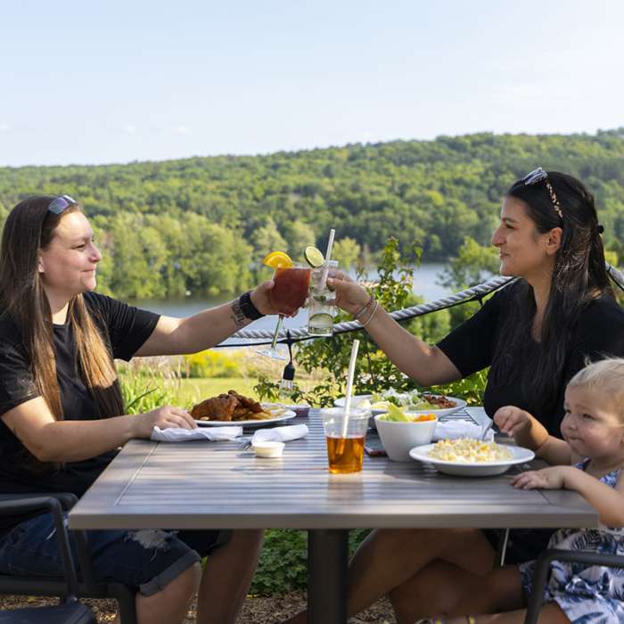 Two parents and their daughter enjoying lunch on the patio