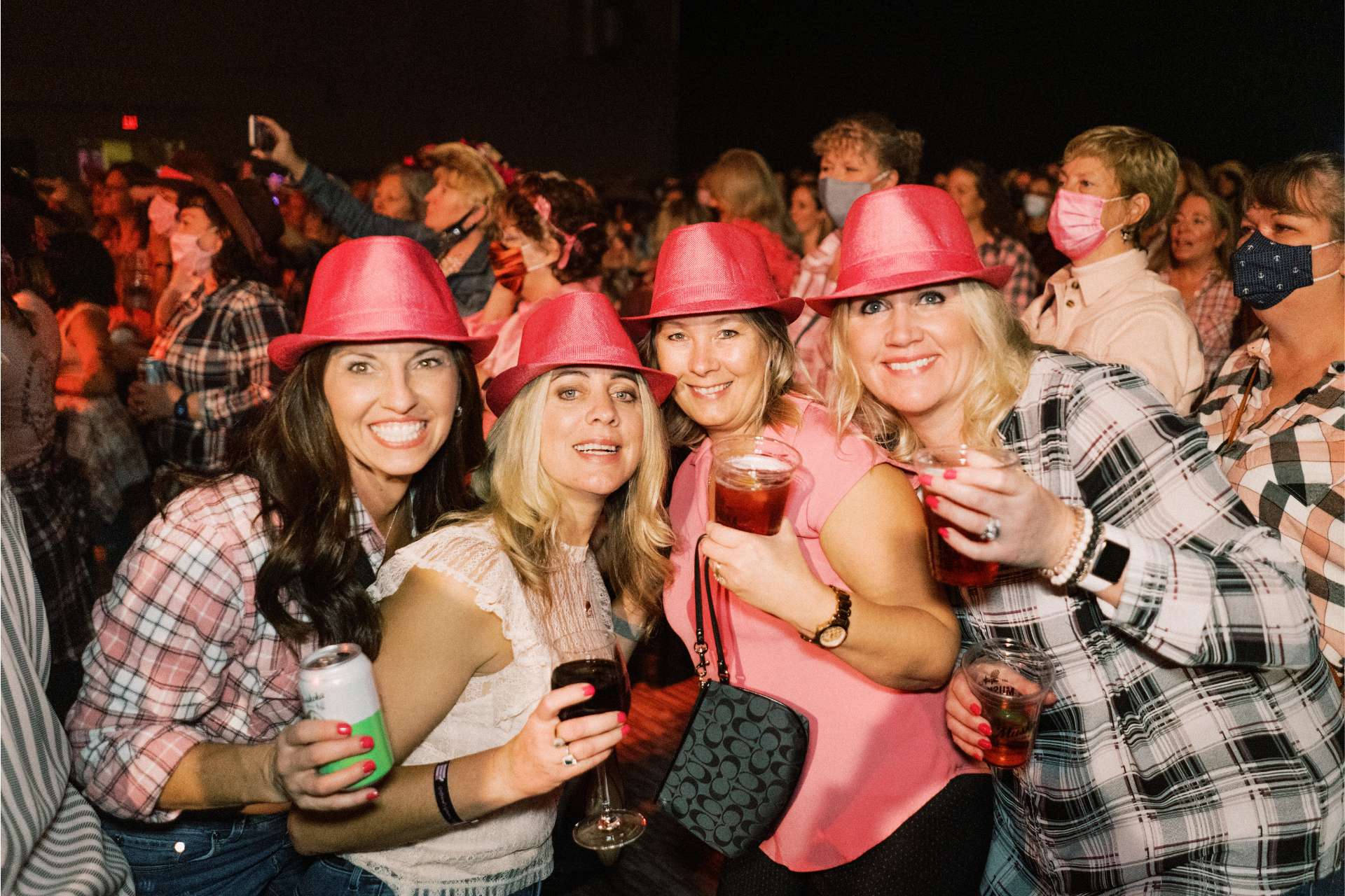 A group of 4 women in pink cowboy hats