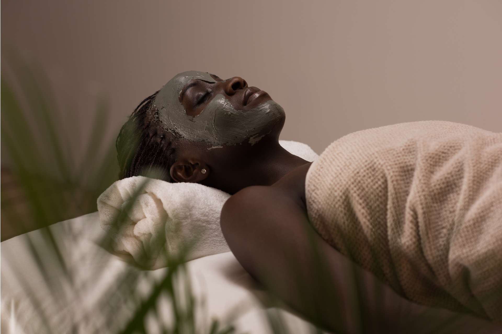 Woman laying on a spa table with a facial mask