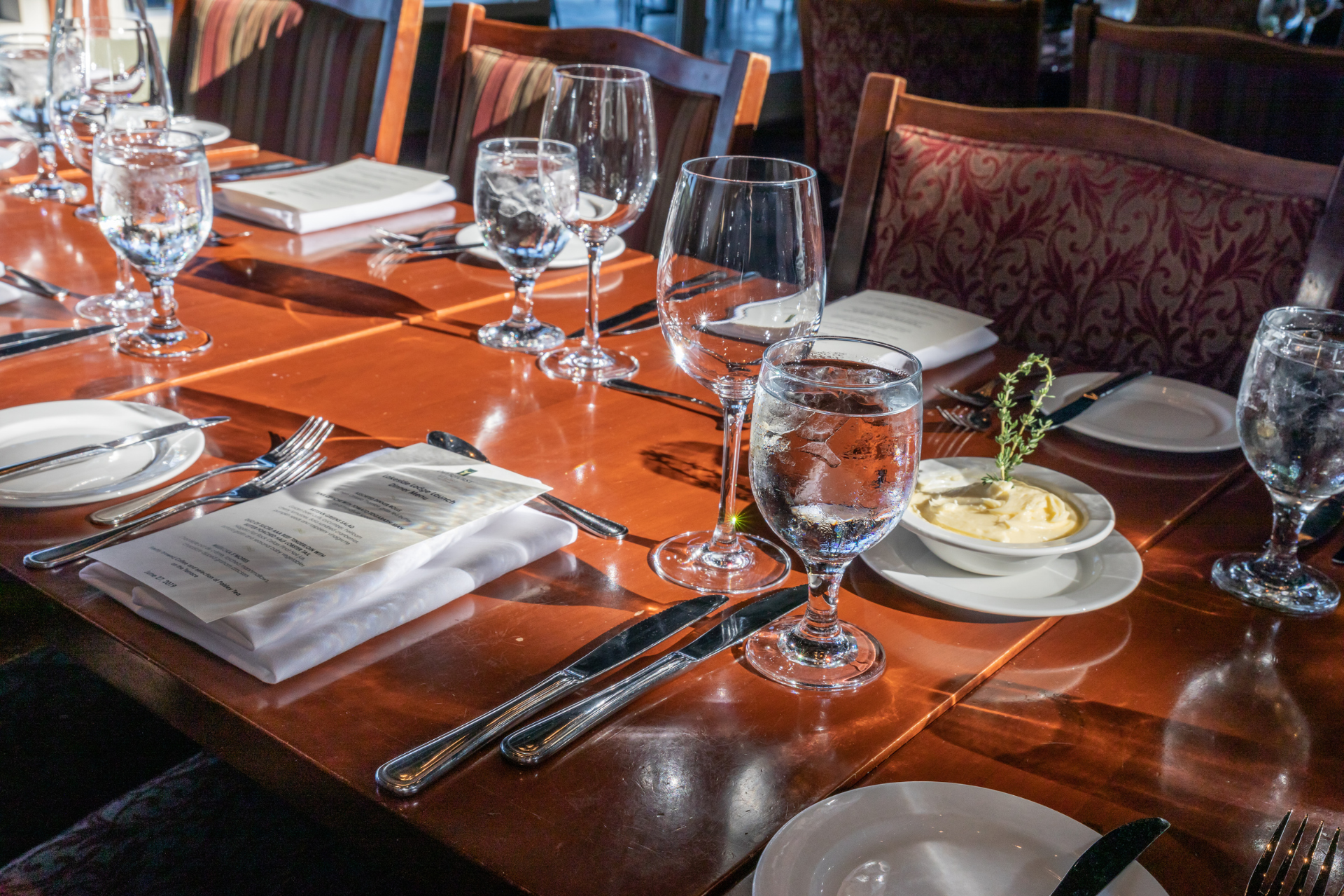A table set with water glasses and menus
