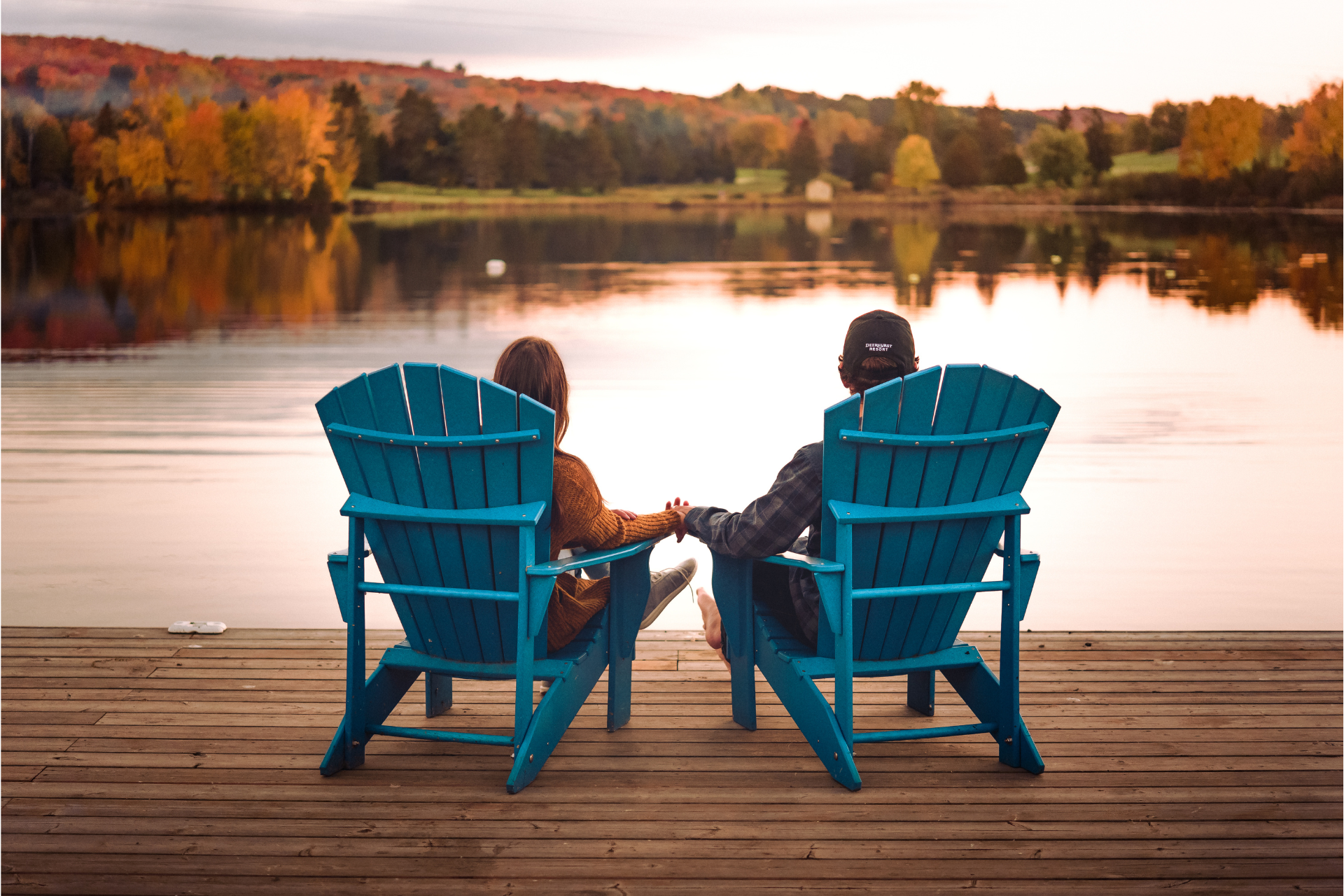 Muskoka chairs on a dock facing the lake